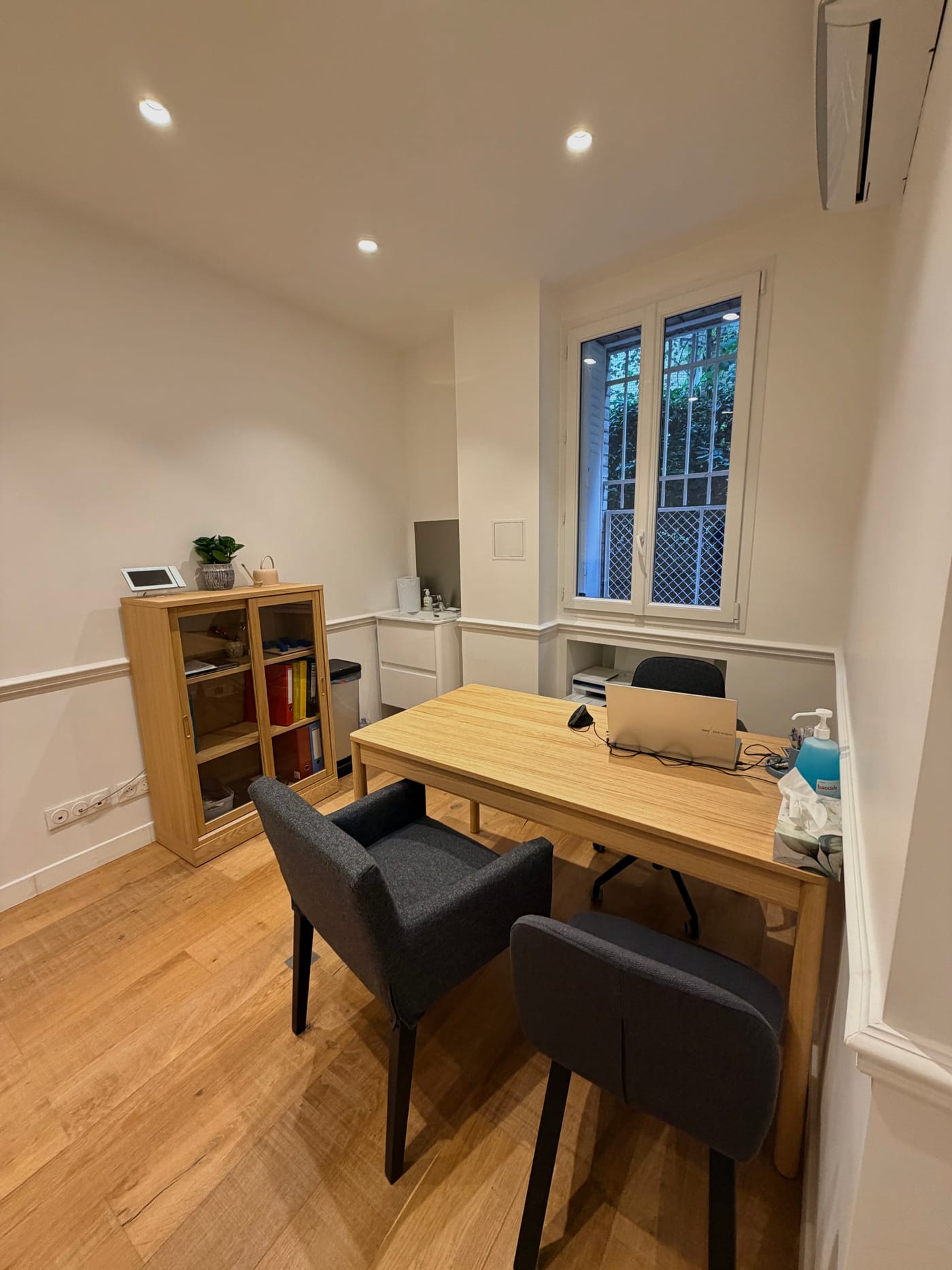 Le cabinet de consultation : bureau lumineux avec fauteuils et parquet